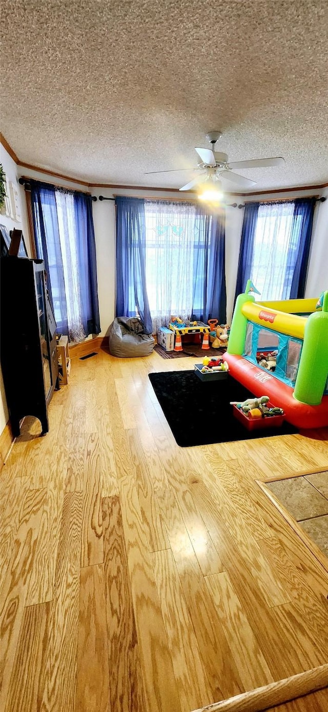 unfurnished bedroom with ceiling fan, a textured ceiling, and hardwood / wood-style flooring