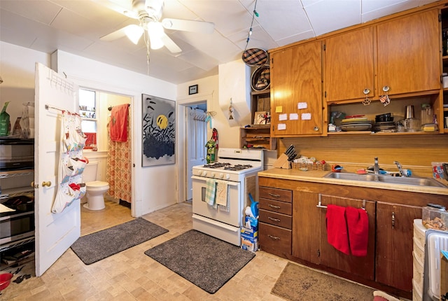 kitchen with sink, ceiling fan, and gas range gas stove