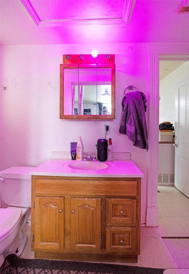 bathroom featuring toilet, a raised ceiling, tile patterned flooring, and vanity