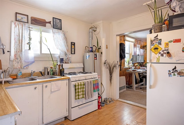 kitchen with sink, a wealth of natural light, white appliances, and light hardwood / wood-style floors