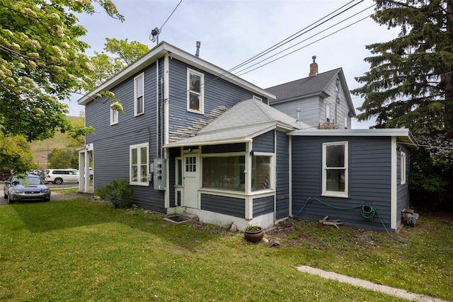333 N 2nd St W, Missoula, MT 59802 - rear view of house with a sunroom, a yard, and a chimney