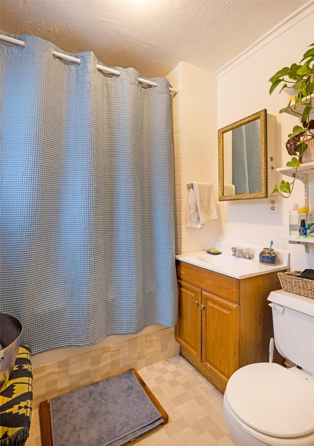 333 N 2nd St W, Missoula, MT 59802 - bathroom with toilet, vanity, a textured ceiling, shower / tub combo with curtain, and tile patterned floors