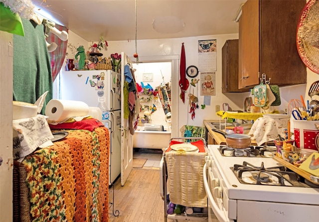 kitchen with white appliances and light hardwood / wood-style floors