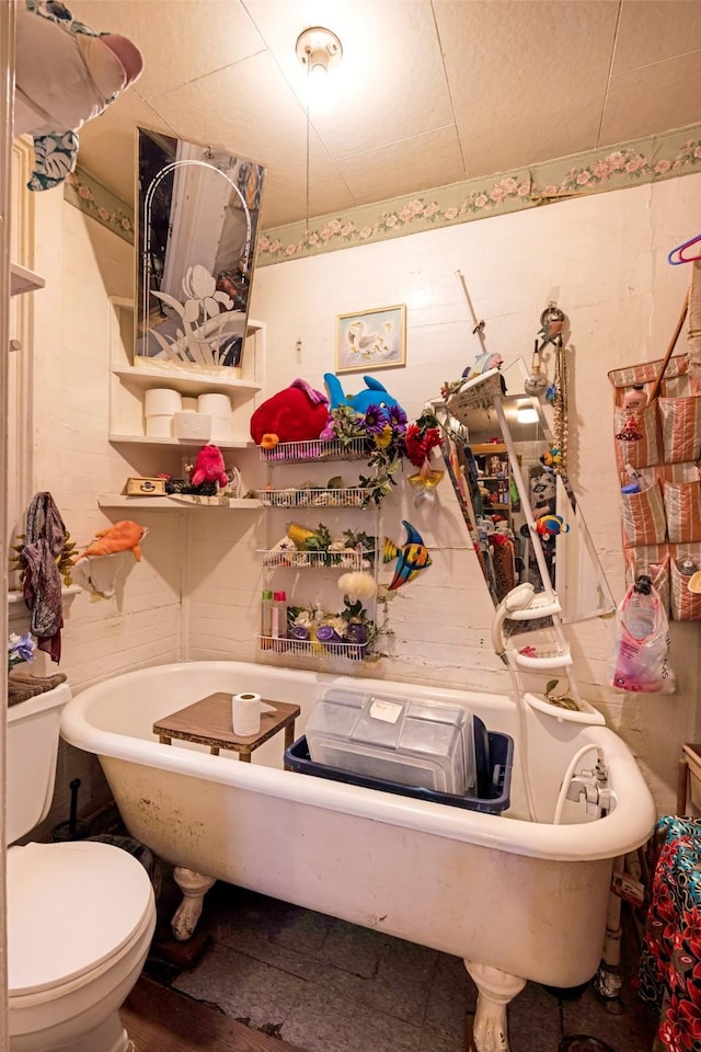 bathroom featuring a tub to relax in and toilet