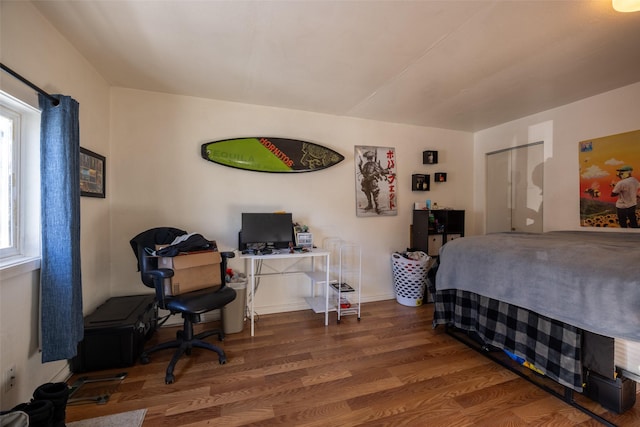 bedroom with hardwood / wood-style floors and multiple windows