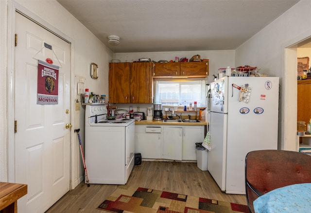 kitchen with white cabinets, light wood-type flooring, white appliances, and sink