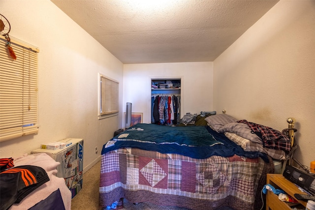 carpeted bedroom with a textured ceiling and a closet