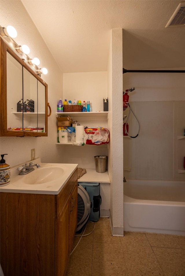 bathroom featuring vanity, shower / bathing tub combination, a textured ceiling, and tile patterned flooring