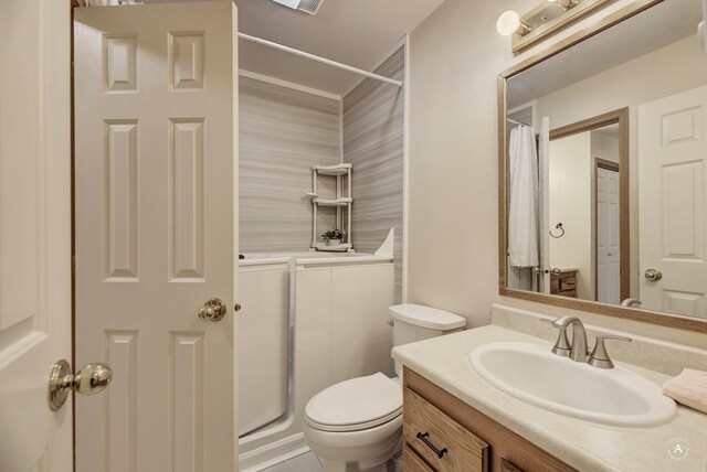 bathroom with toilet, vanity, and walk in shower