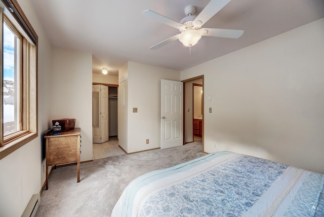 bedroom featuring ceiling fan, multiple windows, a baseboard heating unit, and a closet