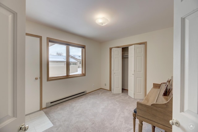 carpeted bedroom featuring a baseboard heating unit and a closet