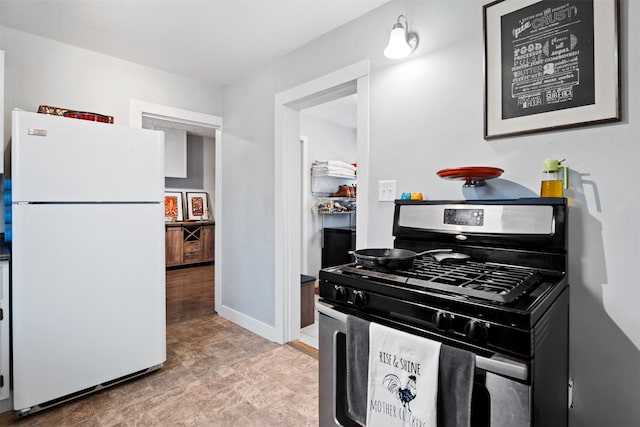 kitchen with stainless steel gas range oven and white fridge