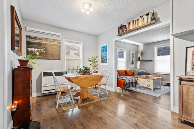 dining space featuring dark hardwood / wood-style flooring, plenty of natural light, and heating unit