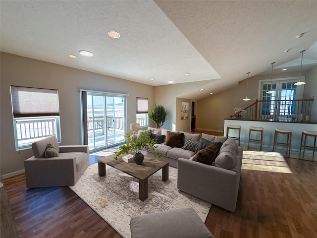 living room featuring a textured ceiling, lofted ceiling, and dark hardwood / wood-style flooring