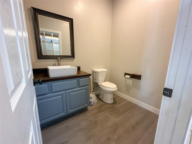 bathroom featuring vanity, toilet, and hardwood / wood-style floors