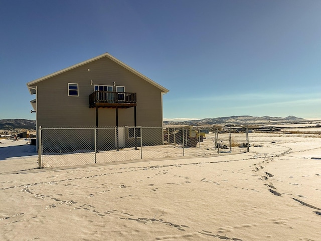 rear view of house with a balcony and a mountain view