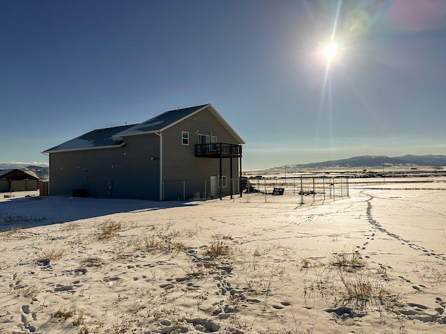 view of side of home featuring a mountain view, a balcony, and a rural view