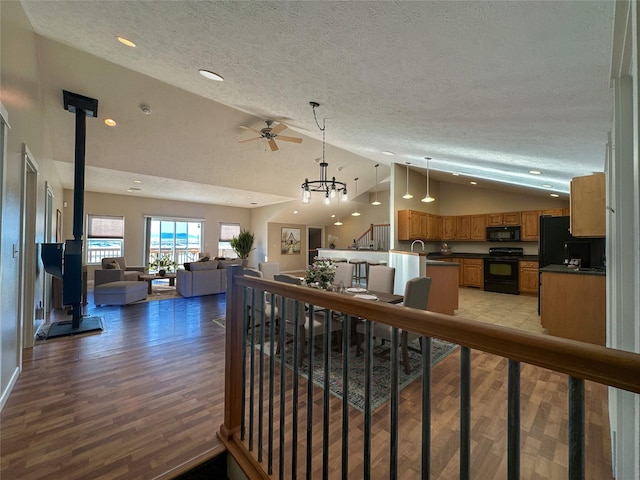 living room featuring light wood-type flooring, a chandelier, a textured ceiling, and high vaulted ceiling