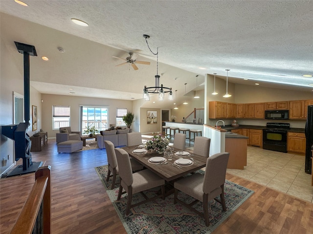 dining area with sink, light hardwood / wood-style flooring, a textured ceiling, and a wood stove