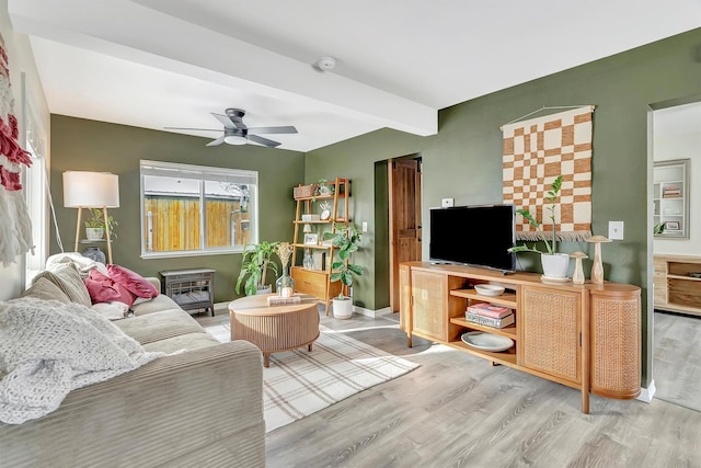 living room with light hardwood / wood-style floors, beam ceiling, and ceiling fan