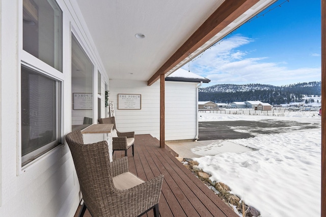 snow covered deck featuring a mountain view