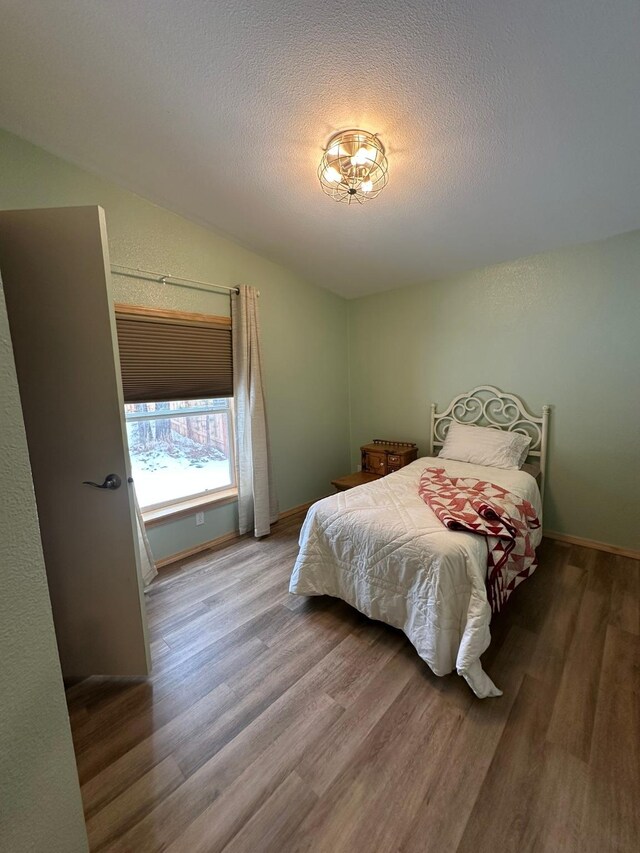 full bathroom featuring hardwood / wood-style flooring, vanity, shower / bath combination with curtain, a textured ceiling, and toilet