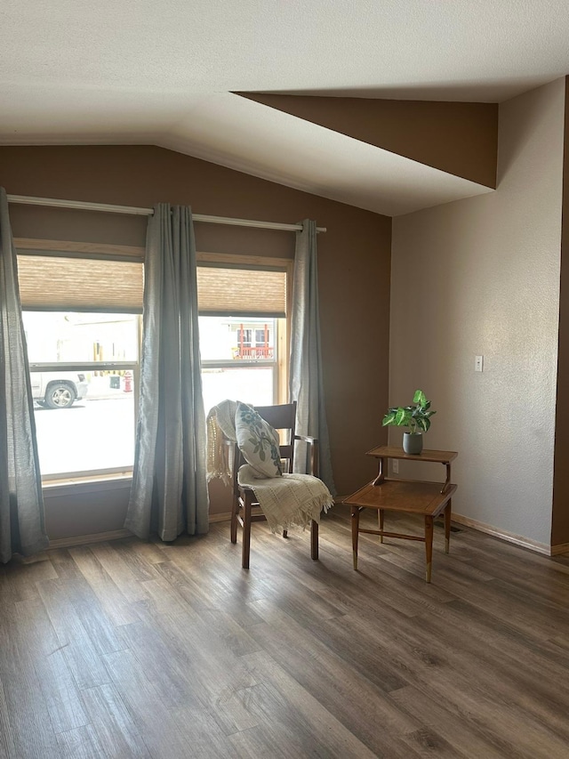 sitting room featuring hardwood / wood-style flooring, lofted ceiling, and a textured ceiling