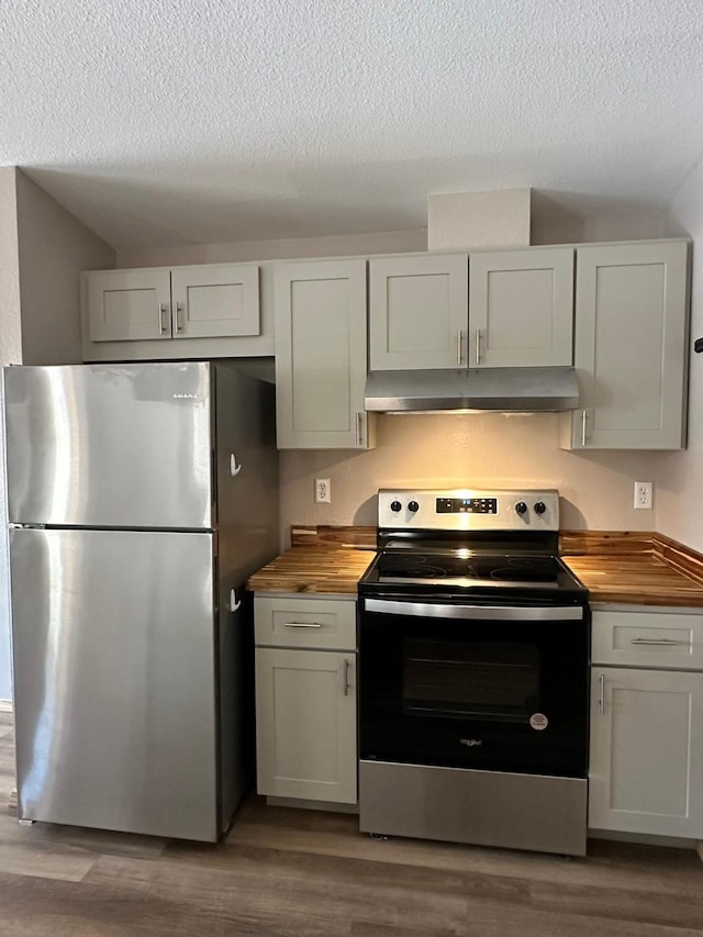 kitchen featuring appliances with stainless steel finishes, white cabinets, wood counters, and light hardwood / wood-style floors