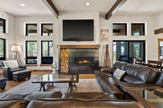 living room with beamed ceiling, hardwood / wood-style floors, and a fireplace