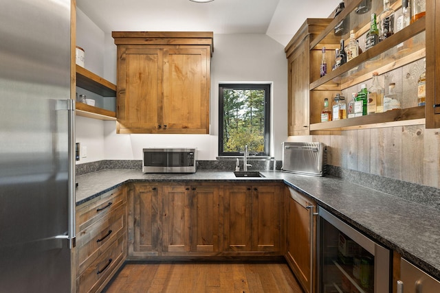 kitchen with sink, wood-type flooring, beverage cooler, and stainless steel appliances