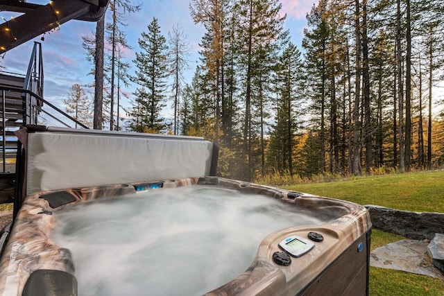 yard at dusk featuring a hot tub