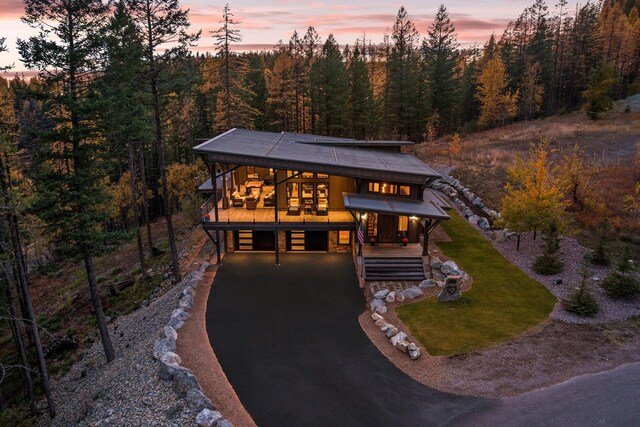 back house at dusk featuring cooling unit, a patio, and a lawn