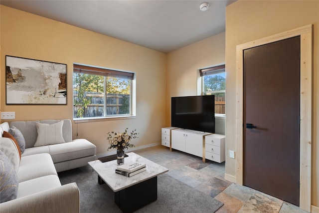 living room featuring stone finish flooring and baseboards