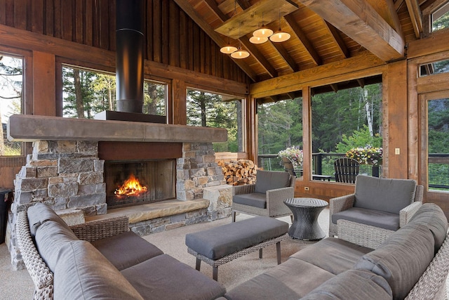 sunroom / solarium featuring wooden ceiling, an outdoor stone fireplace, and vaulted ceiling with beams