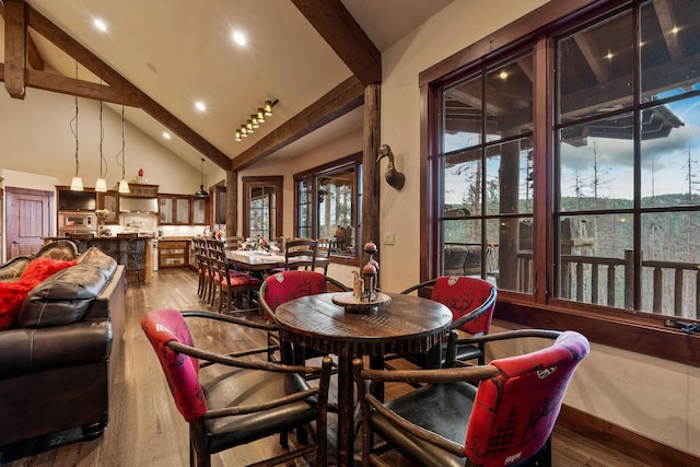 dining area with hardwood / wood-style flooring, high vaulted ceiling, and beam ceiling