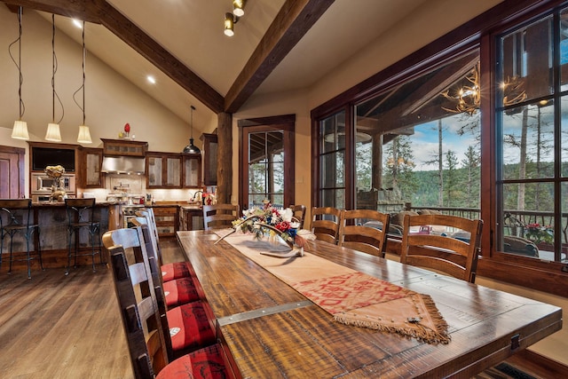 dining space featuring high vaulted ceiling, wood-type flooring, and beamed ceiling