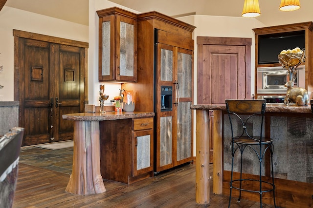 kitchen featuring a kitchen breakfast bar, dark wood-type flooring, and kitchen peninsula