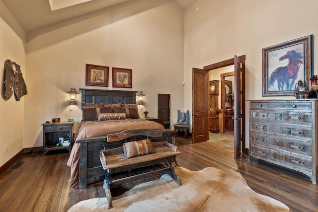 bedroom with hardwood / wood-style flooring and high vaulted ceiling