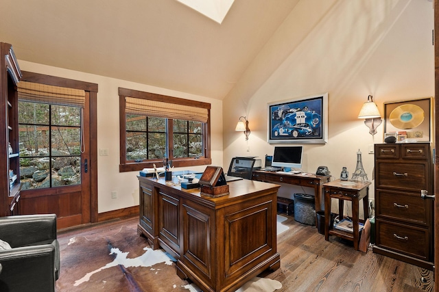 home office featuring dark wood-type flooring and vaulted ceiling with skylight