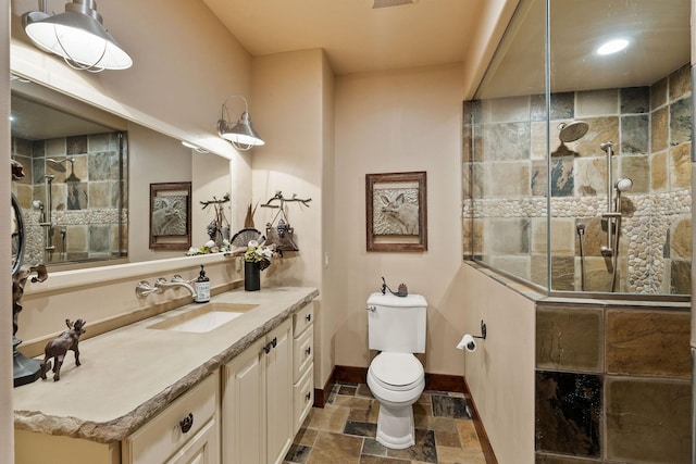 bathroom featuring toilet, walk in shower, and vanity