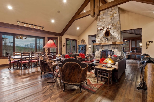 living room featuring a fireplace, hardwood / wood-style floors, beam ceiling, and high vaulted ceiling