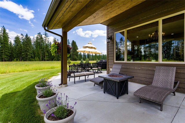 back of house with an outdoor fire pit, a patio, and a yard