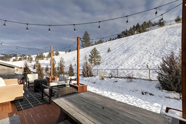 snow covered deck with a mountain view and an outdoor living space