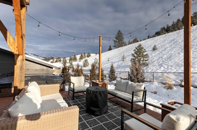 snow covered patio featuring an outdoor living space and a mountain view