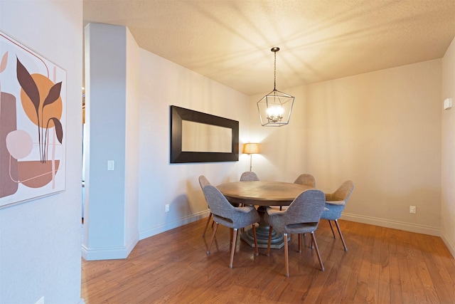 dining room featuring hardwood / wood-style floors and an inviting chandelier