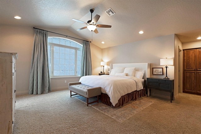 carpeted bedroom with lofted ceiling, a textured ceiling, and ceiling fan