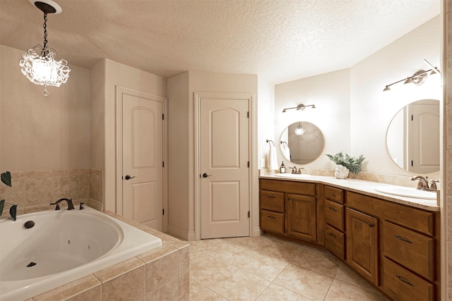 bathroom featuring vanity, tiled bath, a textured ceiling, and tile patterned flooring