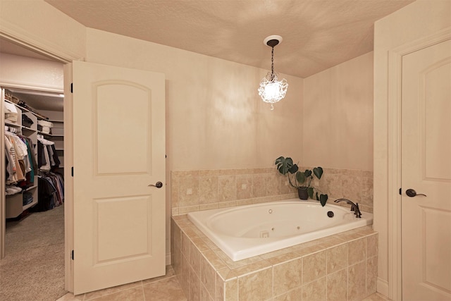 bathroom featuring tiled bath, a textured ceiling, and tile patterned flooring