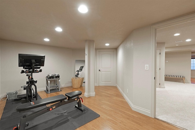 exercise room with light hardwood / wood-style flooring