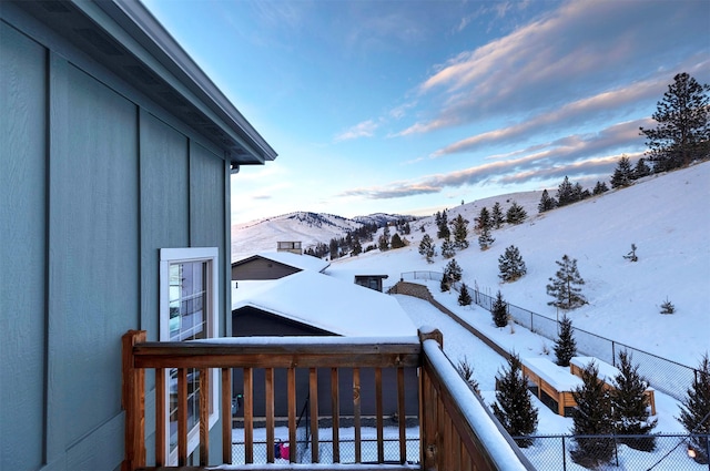 snow covered back of property with a mountain view